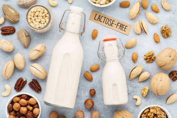 nut milk in bottles and various nuts. lactose free milk substitute. top view.